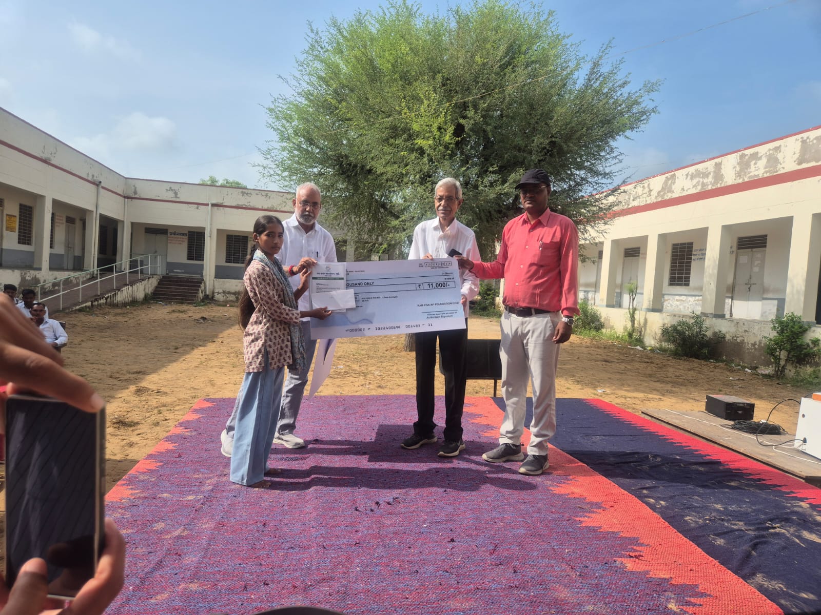 A student receiving a scholarship cheque at an RPS Foundation school event